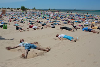 The Ludington Daily News and The Muskegon Chronicle report 1,387 people angelically assembled on a Lake Michigan beachfront in Ludington on Saturday and worked their magic for 30 seconds. That far surpasses the roughly 350 who made sand angels for 15 seconds two years ago in Pembrokeshire, Wales.
